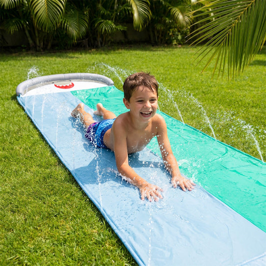 Kind rutscht auf der Hai-Wasserrutsche im Garten