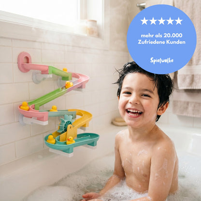 Glückliches Kind beim Spielen mit der Kugelbahn in der Badewanne