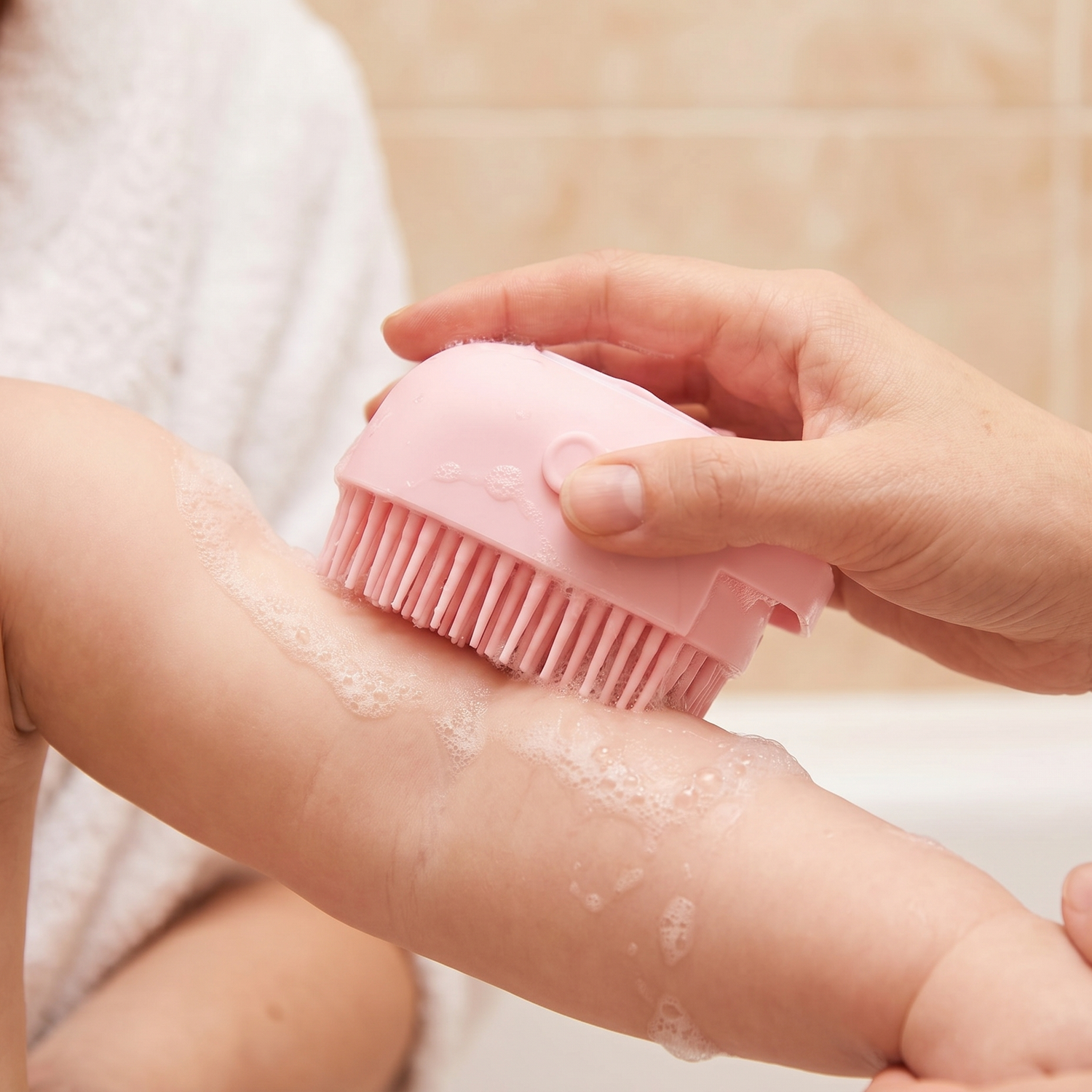 Silikon-Massagebürste gleitet sanft mit Schaum über Babyhaut