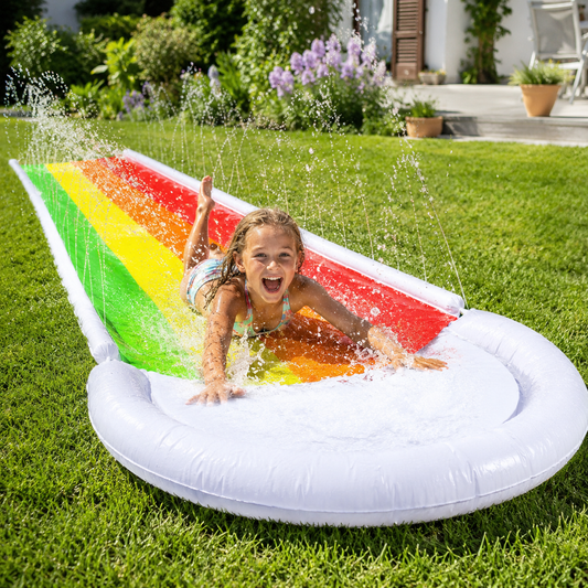 Kind rutscht lachend über die Regenbogen-Wasserrutschbahn im Garten