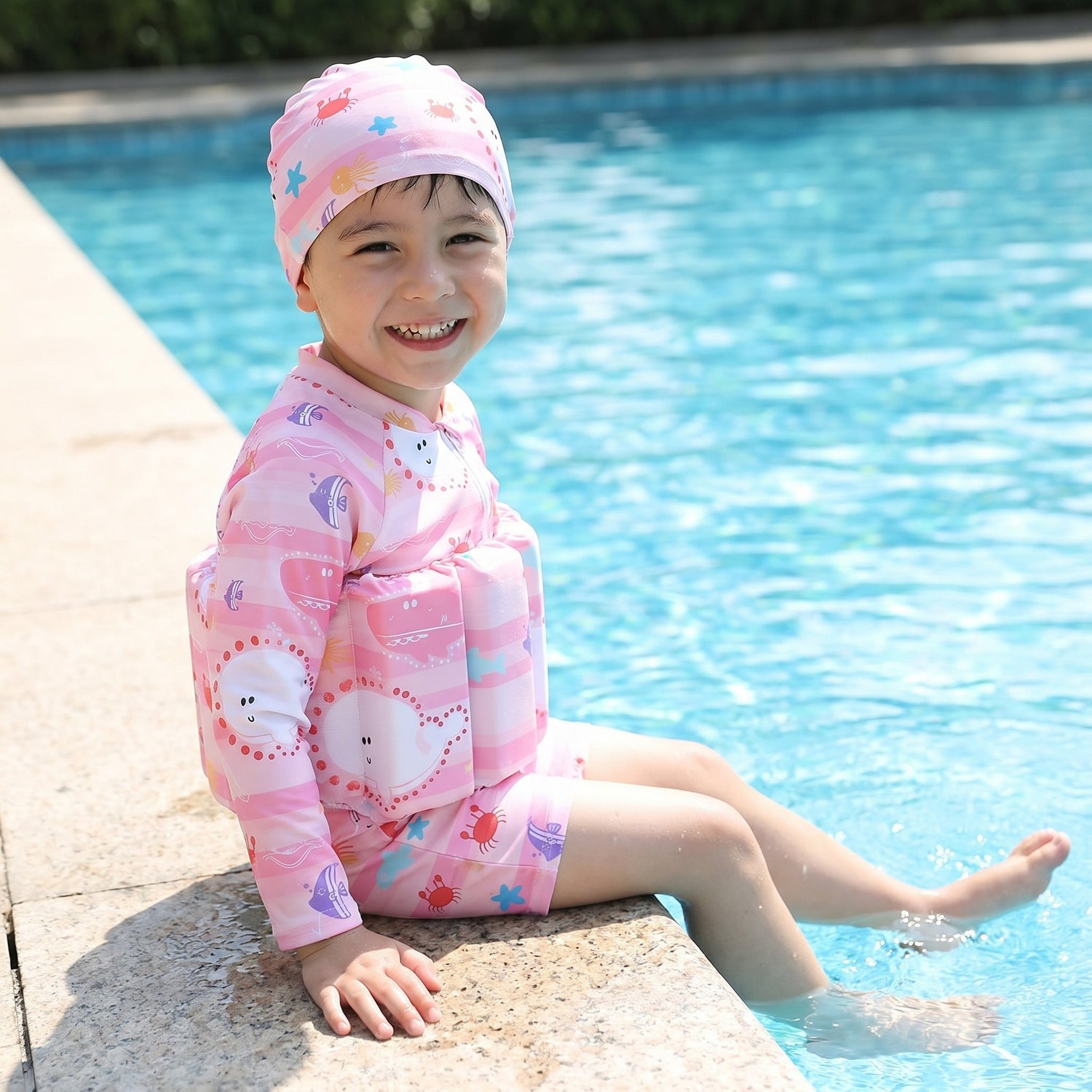 Kind freut sich ueber den Kinder-Schwimmanzug am Pool