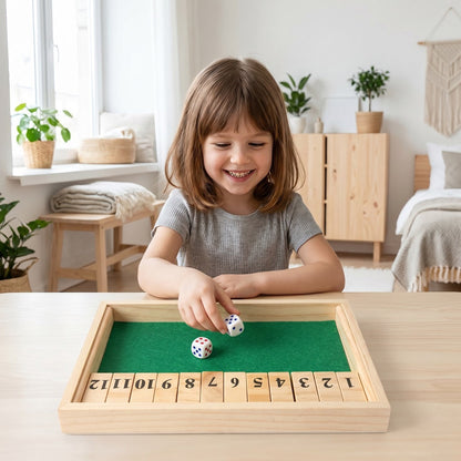 Mädchen spielt den Zahlen-Würfelturm aus Holz am Tisch